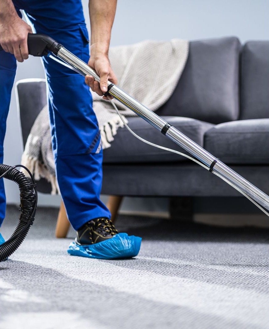 Professional carpet cleaner using a vacuum in a living room